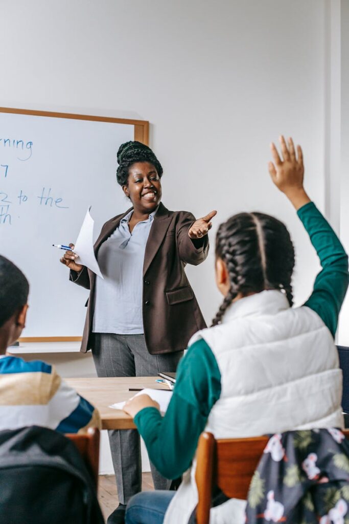 A teacher interacts with students in a classroom, fostering an engaging learning environment.