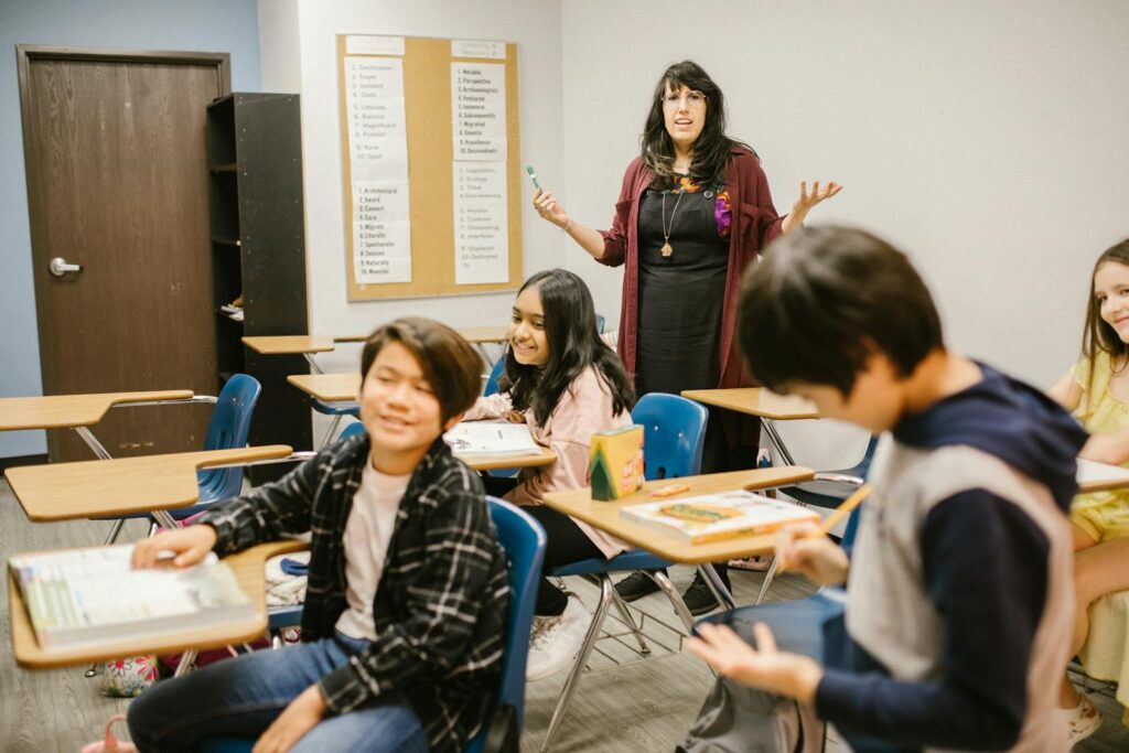 Students and teacher interacting in a lively classroom setting, promoting educational engagement.